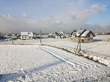 Houses on snow covered land against sky