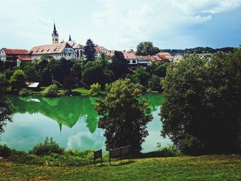 Scenic view of lake by buildings against sky