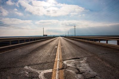 Road by bridge against sky