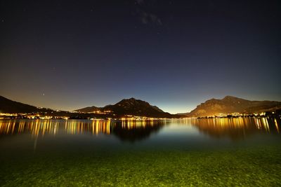 Scenic view of lake against sky at night