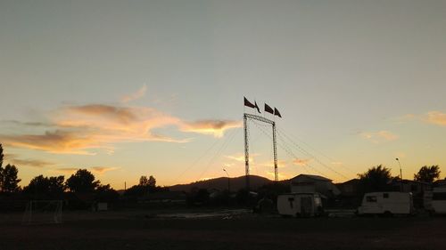 Silhouette cranes against sky during sunset