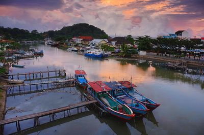 High angle view of boats moored in lake against cloudy sky at sunset