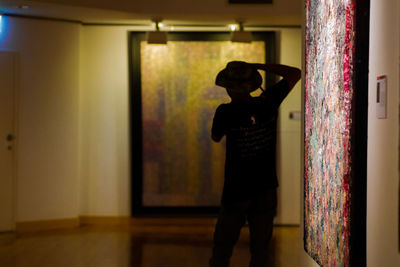 Side view of man standing at home