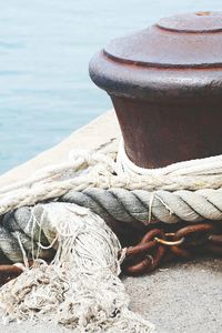 Close-up of rope tied to bollard on beach