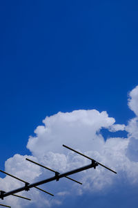 Low angle view of power lines against blue sky