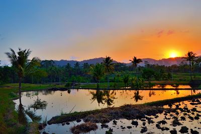 Scenic view of lake against sky during sunset