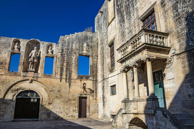 Low angle view of old building against blue sky