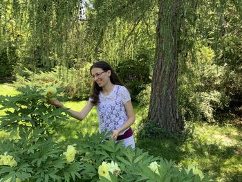 Rear view of woman standing amidst plants