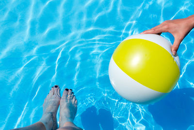 Low section of woman with female friend in swimming pool