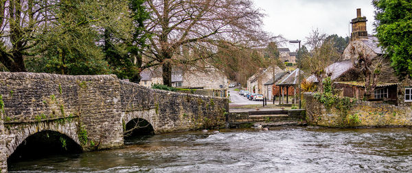 Arch bridge over river against buildings