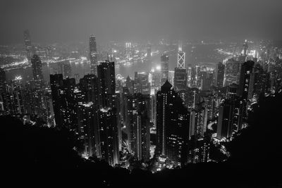 Illuminated buildings in city against sky at night