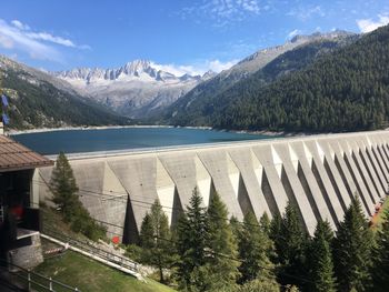 Scenic view of dam and mountains against sky