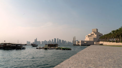 Scenic view of sea by buildings against sky