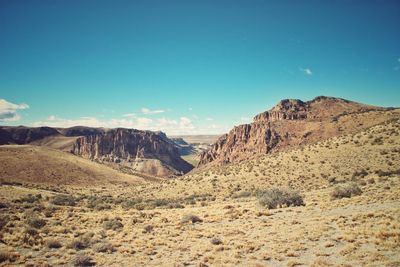 Scenic view of rocky mountains against blue sky