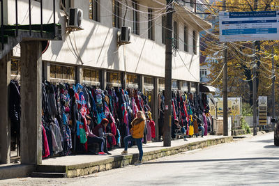 People on street against buildings in city