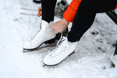 Pictured are hands tying ice skates. a young woman came to skate on an ice rink. winter fun