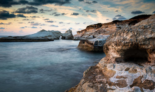 Rocky seashore seascape with wavy ocean and dramatic and beautiful sunset at the seascapes