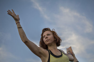 Low angle view of woman standing against sky