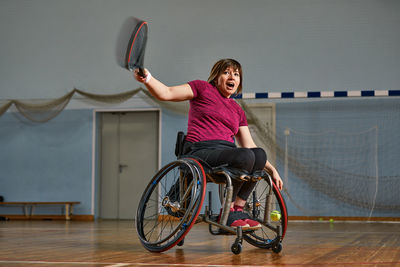 Portrait of young woman with bicycle in gym