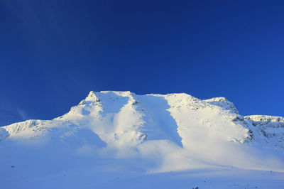 Scenic view of snowcapped mountains against clear blue sky