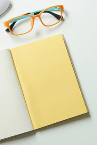 Close-up of eyeglasses on table against white background