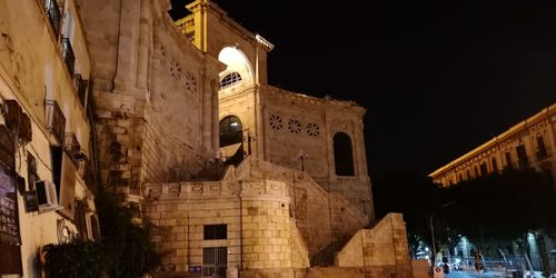 Low angle view of illuminated building against sky at night