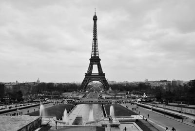 Tower in city against cloudy sky