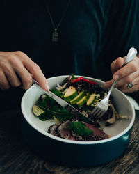 Midsection of person preparing food in bowl on table