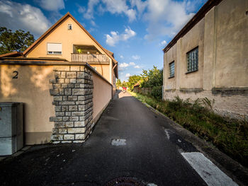 Street amidst buildings in town against sky