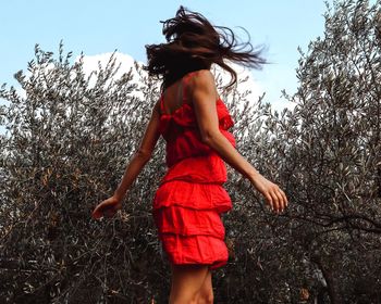 Woman standing with orange dress in motion