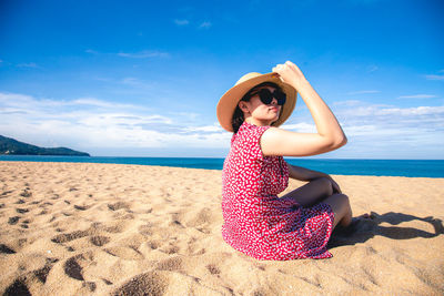 Woman on beach by sea against sky