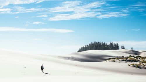 Woman standing on dessert against sky