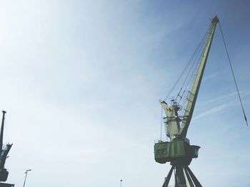 Low angle view of crane against sky