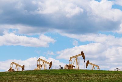 Traditional windmill on field against sky