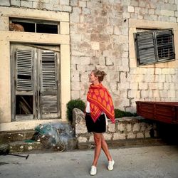 Full length of woman walking against building