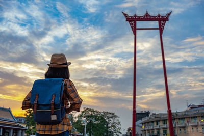 Rear view of man looking at city against sky