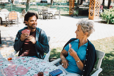 Woman sitting on a table with people in background