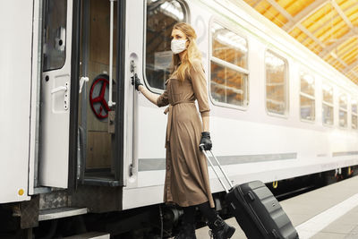 Woman standing by train at railroad station platform