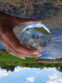 Reflection of person holding umbrella in water