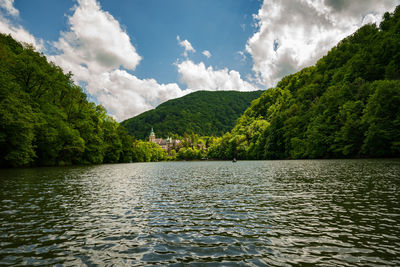 Scenic view of lake by trees against sky