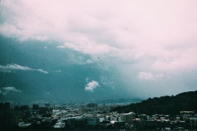 Cityscape against cloudy sky
