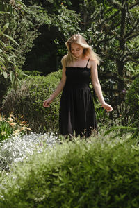 Happy blond woman walking barefoot in the park or garden. freedom and healthy way of life. female in