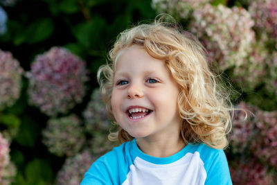 Smiling girl looking away against plants