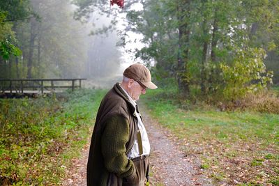 Profile view of senior man standing in forest