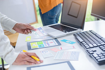 Midsection of man using laptop on table