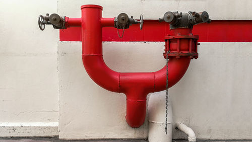 Close-up of red fire hydrant against wall