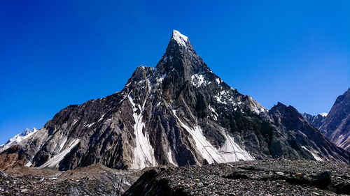 Low angle view of rock formation against clear blue sky