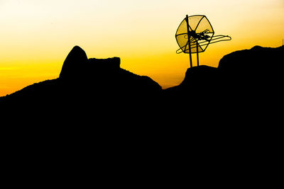 Silhouette mountain against orange sky