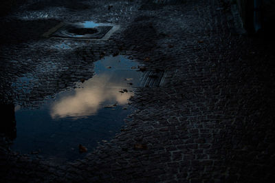 Reflection of building in puddle on street