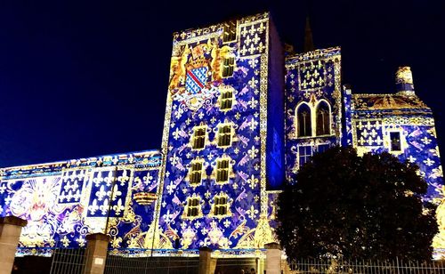 Low angle view of illuminated building against sky at night